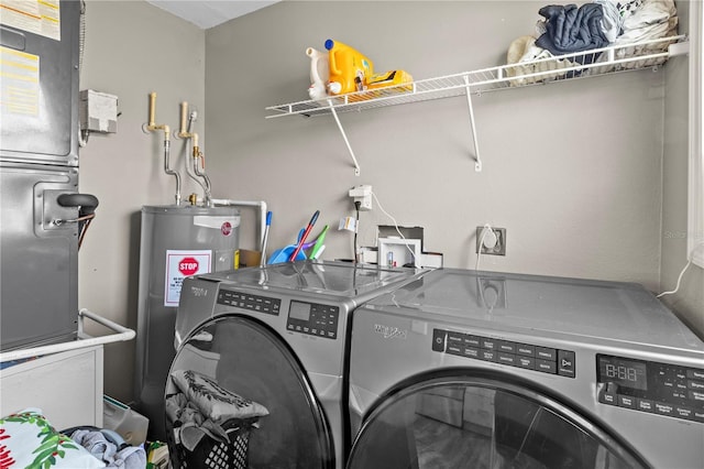 laundry room featuring water heater and independent washer and dryer