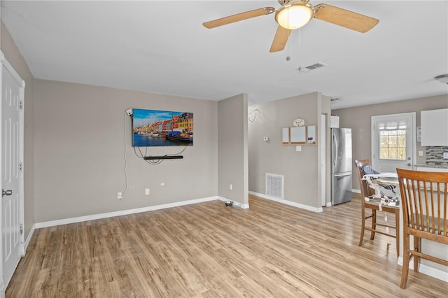 living room with ceiling fan and light wood-type flooring