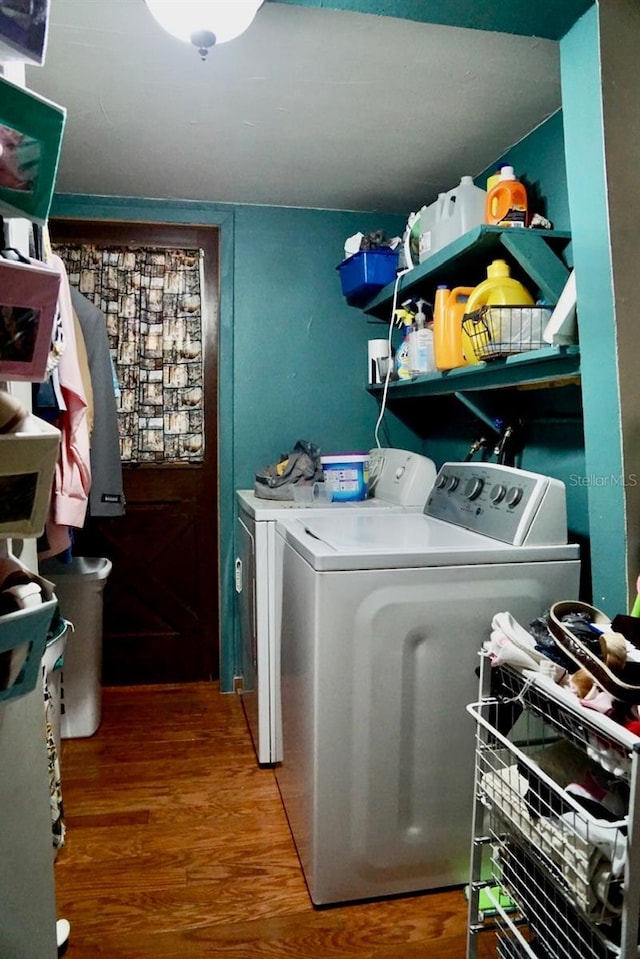 laundry room featuring wood-type flooring and separate washer and dryer