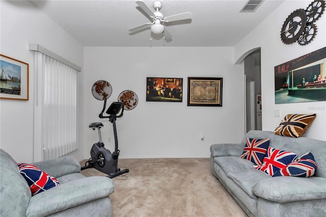 living room with light carpet, a textured ceiling, and ceiling fan