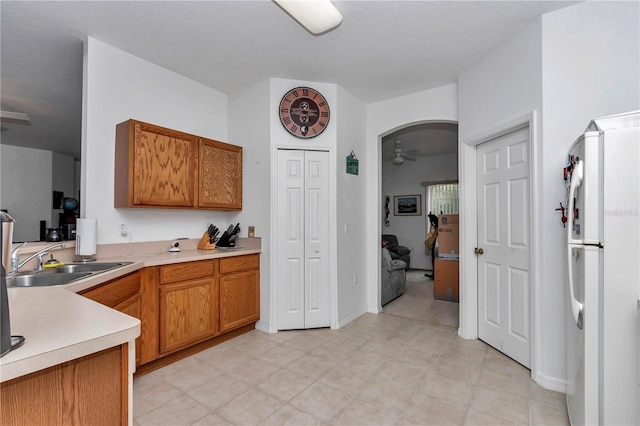 kitchen featuring sink, ceiling fan, and white fridge