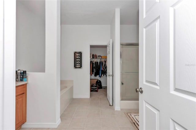 bathroom featuring tile patterned flooring and separate shower and tub