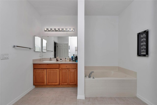 bathroom with vanity, tiled tub, and tile patterned flooring