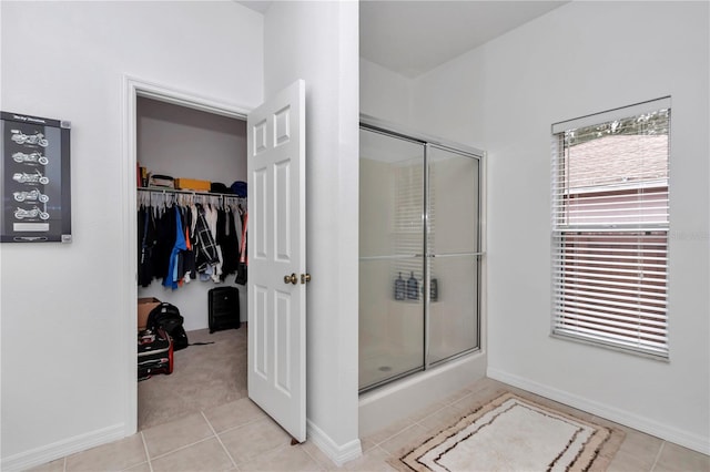 bathroom with an enclosed shower and tile patterned floors