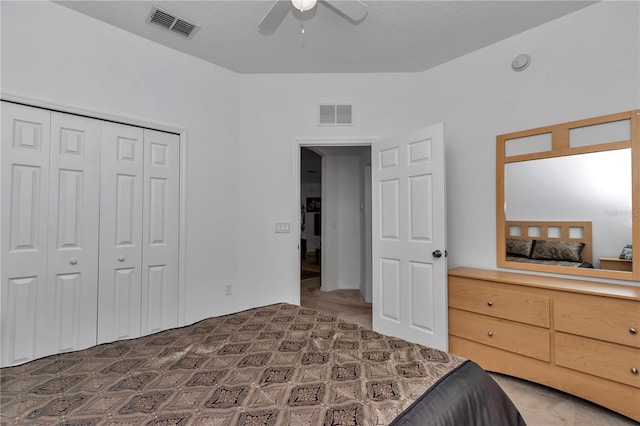 carpeted bedroom featuring ceiling fan and a closet