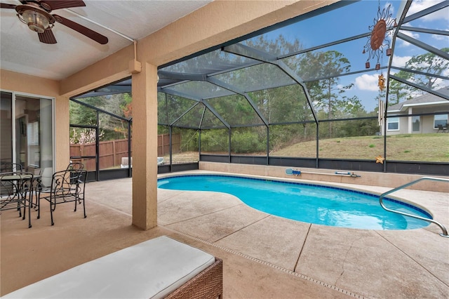 view of swimming pool featuring ceiling fan, a patio area, and glass enclosure