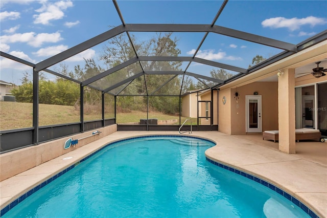 view of swimming pool featuring a patio, ceiling fan, and glass enclosure