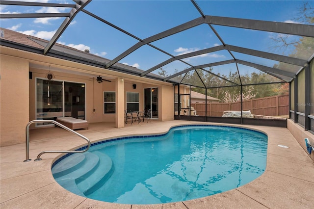 view of pool featuring ceiling fan, a patio, and glass enclosure