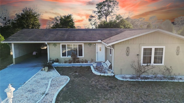 ranch-style home featuring a yard and a carport