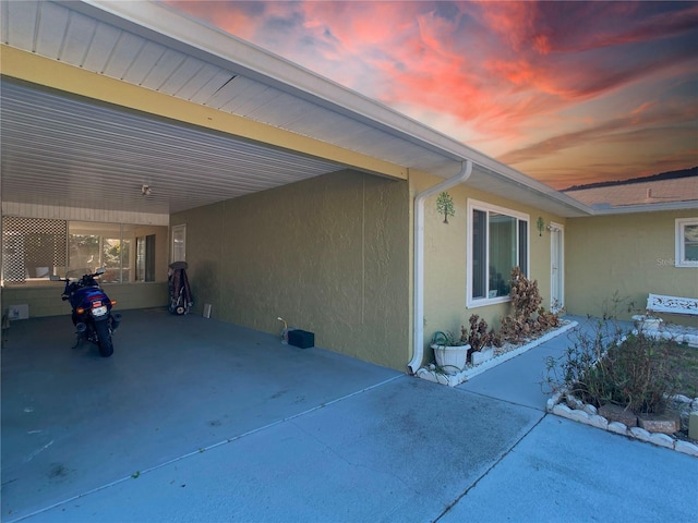 patio terrace at dusk featuring a carport