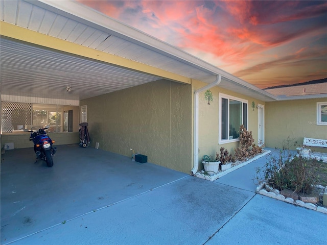 patio terrace at dusk featuring a carport