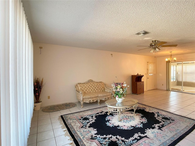 sitting room featuring light tile patterned flooring, ceiling fan, and a textured ceiling