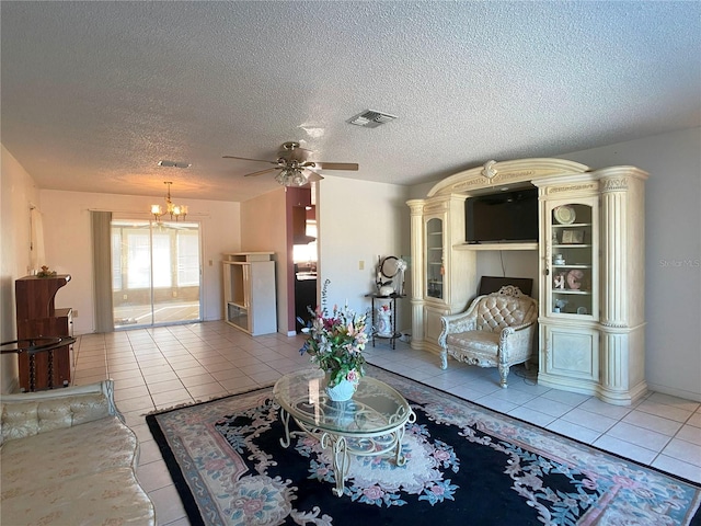 tiled living room featuring ceiling fan with notable chandelier and a textured ceiling