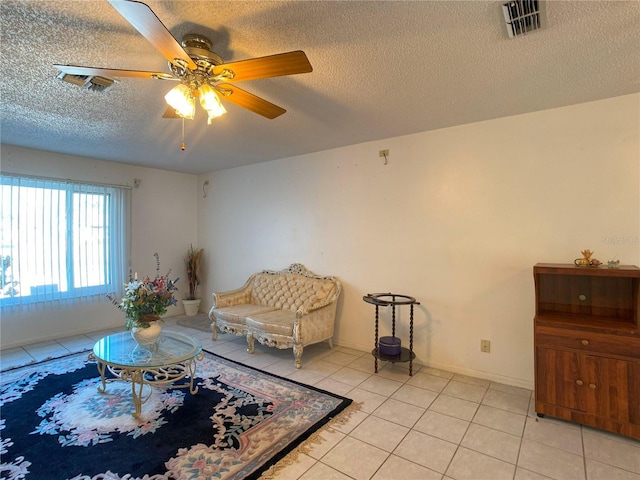 living room with light tile patterned floors, a textured ceiling, and ceiling fan