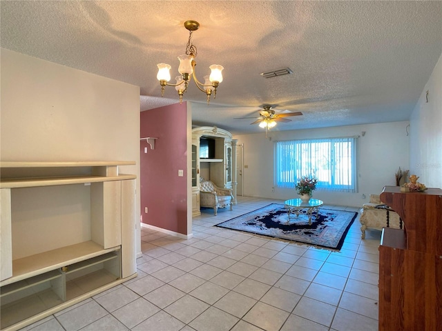 unfurnished living room with ceiling fan with notable chandelier, light tile patterned floors, and a textured ceiling