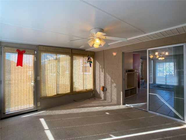 unfurnished sunroom featuring ceiling fan with notable chandelier