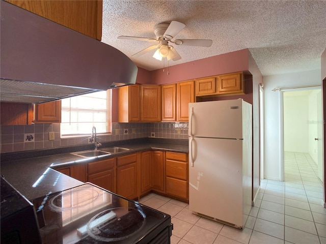 kitchen featuring sink, light tile patterned floors, black range with electric cooktop, white fridge, and decorative backsplash