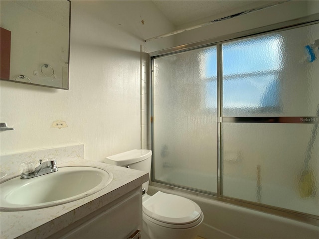 full bathroom featuring vanity, shower / bath combination with glass door, and toilet