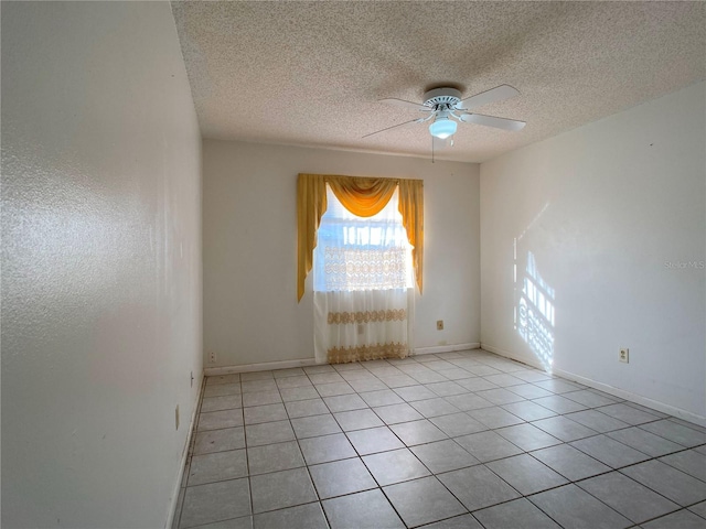 spare room featuring ceiling fan, a textured ceiling, and light tile patterned floors