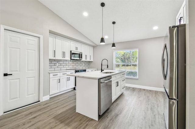 kitchen with a sink, white cabinetry, light countertops, appliances with stainless steel finishes, and an island with sink