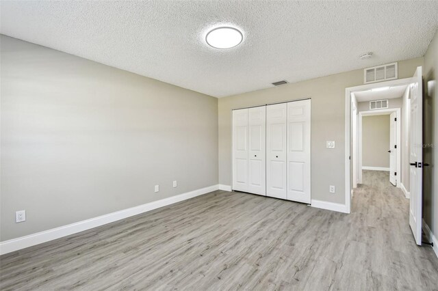 unfurnished bedroom featuring light wood-style flooring, visible vents, and baseboards