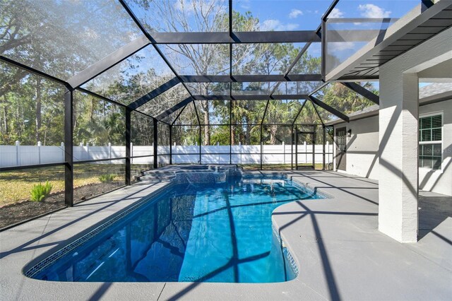 view of pool with a lanai, a patio area, a fenced backyard, and a pool with connected hot tub