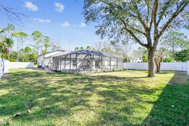 view of yard with glass enclosure and a fenced backyard