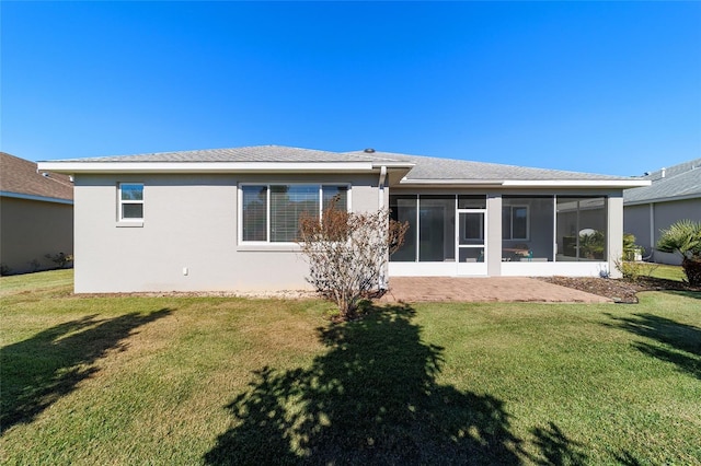 back of property with a sunroom and a lawn