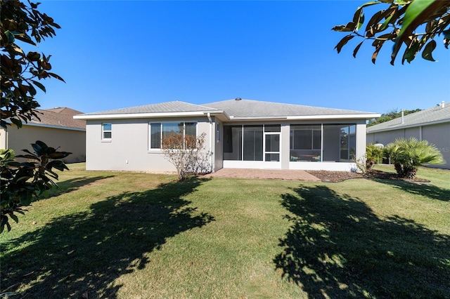 back of house featuring a sunroom and a lawn