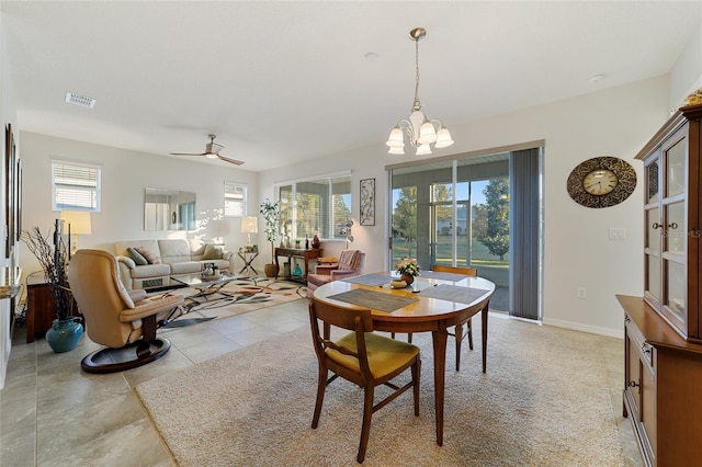 dining space featuring light tile patterned flooring and ceiling fan with notable chandelier