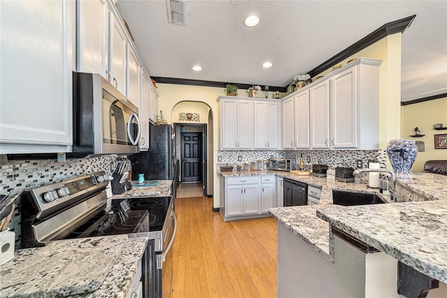 kitchen featuring sink, light stone counters, crown molding, appliances with stainless steel finishes, and white cabinets