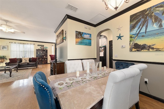 dining room with ceiling fan, ornamental molding, and light hardwood / wood-style flooring