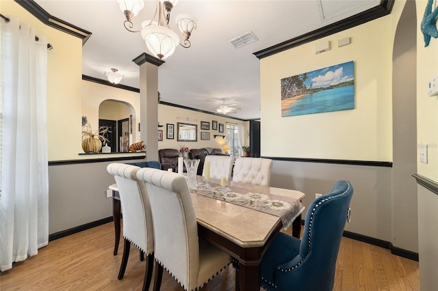 dining area featuring ornamental molding, ceiling fan with notable chandelier, and light hardwood / wood-style flooring