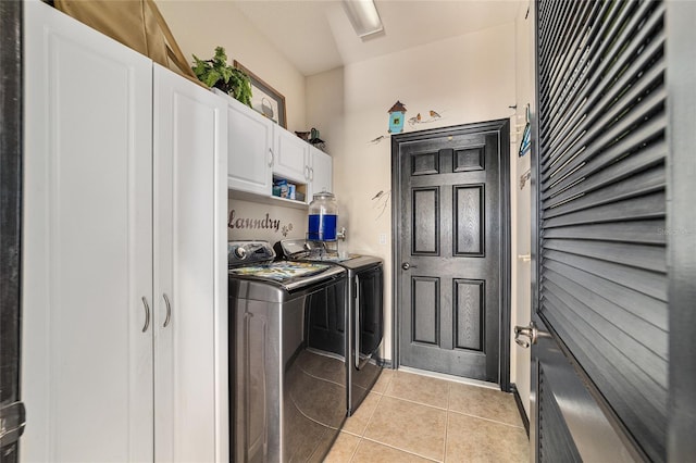 clothes washing area featuring cabinets, separate washer and dryer, and light tile patterned floors