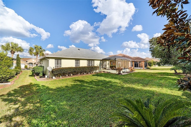 back of house featuring a lanai and a yard