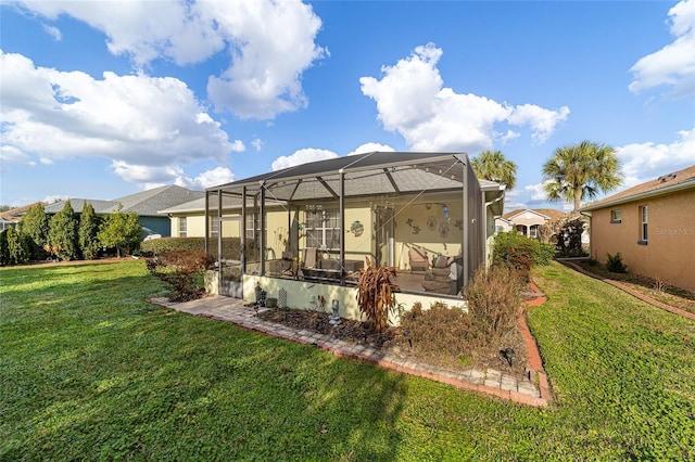 back of property with glass enclosure and a lawn