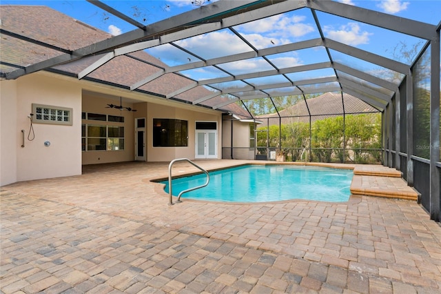 view of swimming pool with french doors, ceiling fan, a patio area, and glass enclosure