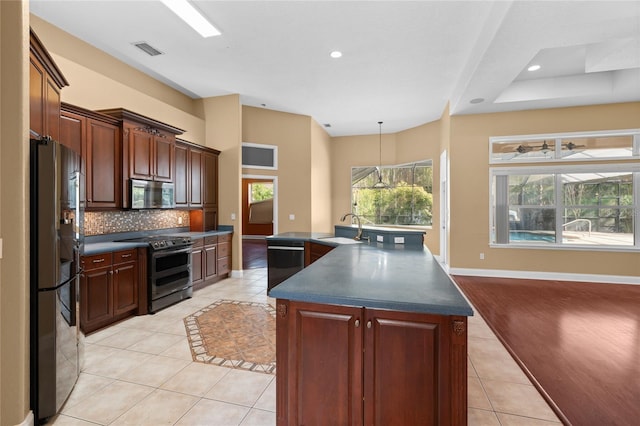 kitchen featuring sink, light tile patterned floors, an island with sink, decorative backsplash, and black appliances