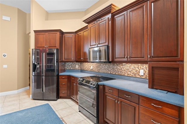 kitchen with light tile patterned flooring, stainless steel appliances, and backsplash