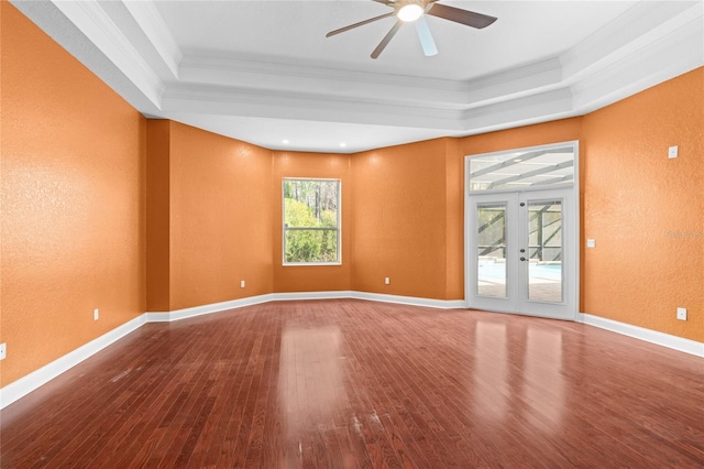 spare room featuring crown molding, ceiling fan, hardwood / wood-style floors, a tray ceiling, and french doors