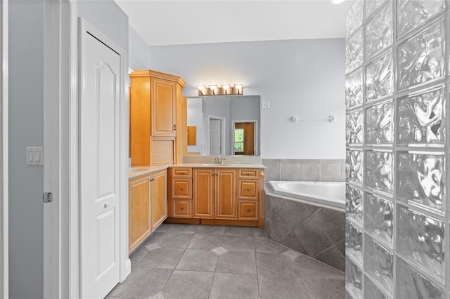 bathroom featuring vanity, tiled bath, and tile patterned flooring