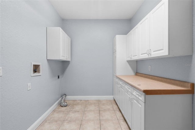 clothes washing area with hookup for a washing machine, hookup for an electric dryer, cabinets, and light tile patterned floors