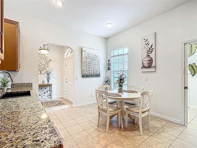 dining area featuring sink and light tile patterned floors