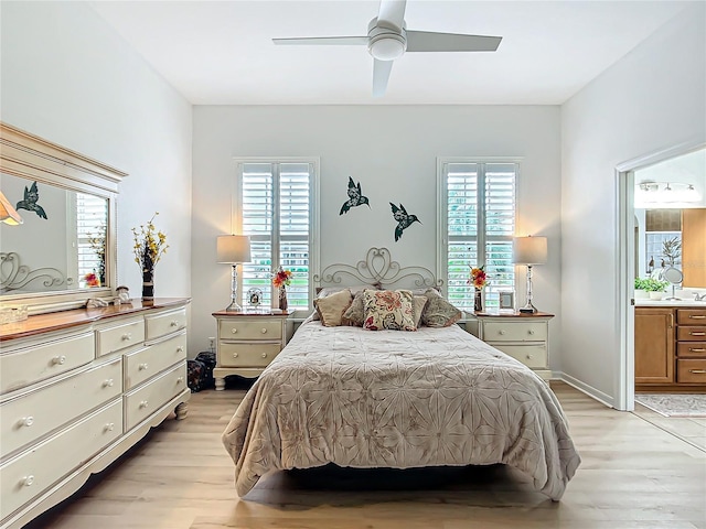 bedroom with multiple windows, ensuite bath, and light wood-type flooring