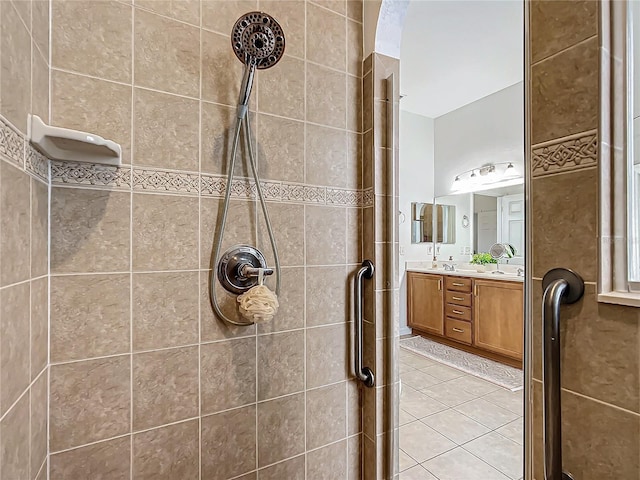 bathroom with vanity, a tile shower, and tile patterned floors