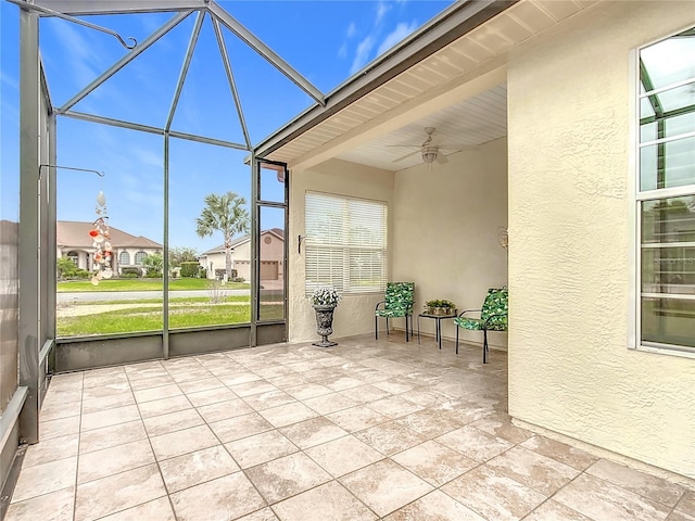 unfurnished sunroom with ceiling fan