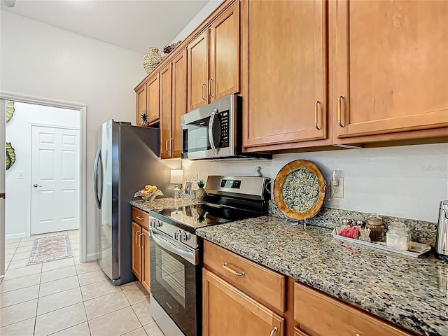 kitchen featuring appliances with stainless steel finishes, light stone countertops, and light tile patterned floors