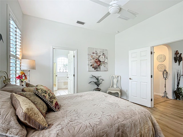 bedroom featuring ceiling fan, multiple windows, and light wood-type flooring