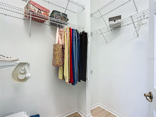 walk in closet with hardwood / wood-style floors