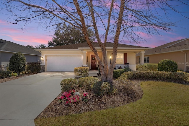 single story home featuring a garage and a lawn